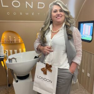 Mulher segurando sacola da London Cosméticos, simbolizando a compra de produtos de beleza e cuidados pessoais.